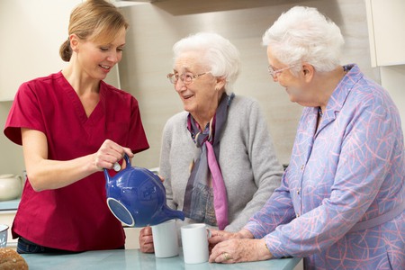Två äldre damer serveras kaffe av yngre kvinna
