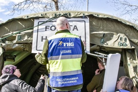 Personer i FRG som sätter upp ett "Första hjälpen-tält"